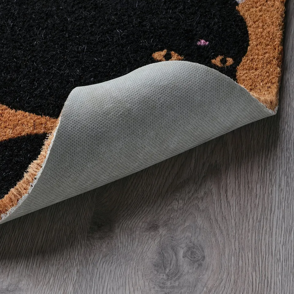 Black and tan cat-themed doormat with textured white non-slip backing.