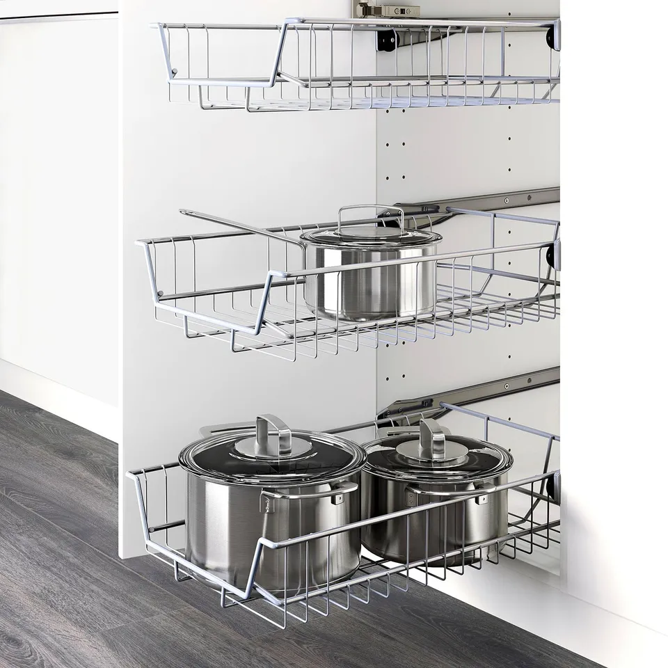 Modern kitchen storage solution with wire baskets holding pots and pans, part of the METOD system.