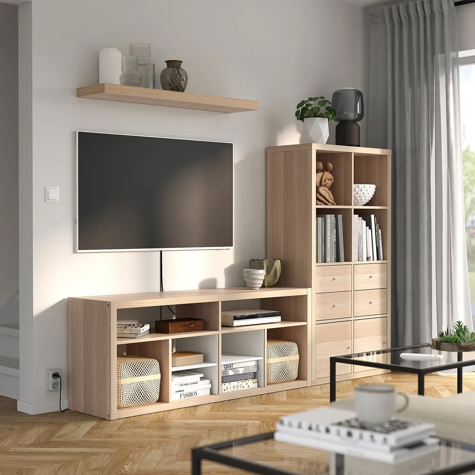 Modern living room with KALLAX tv stand, flat-screen tv, and minimalist decor.