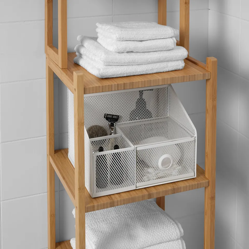 Bathroom organiser shelf with towels and mesh storage bins.