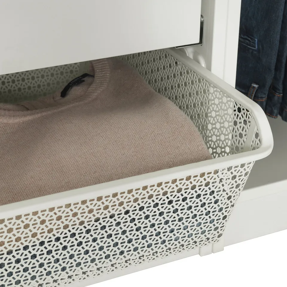 White metal basket in wardrobe holding folded beige sweater, showcasing airflow design.
