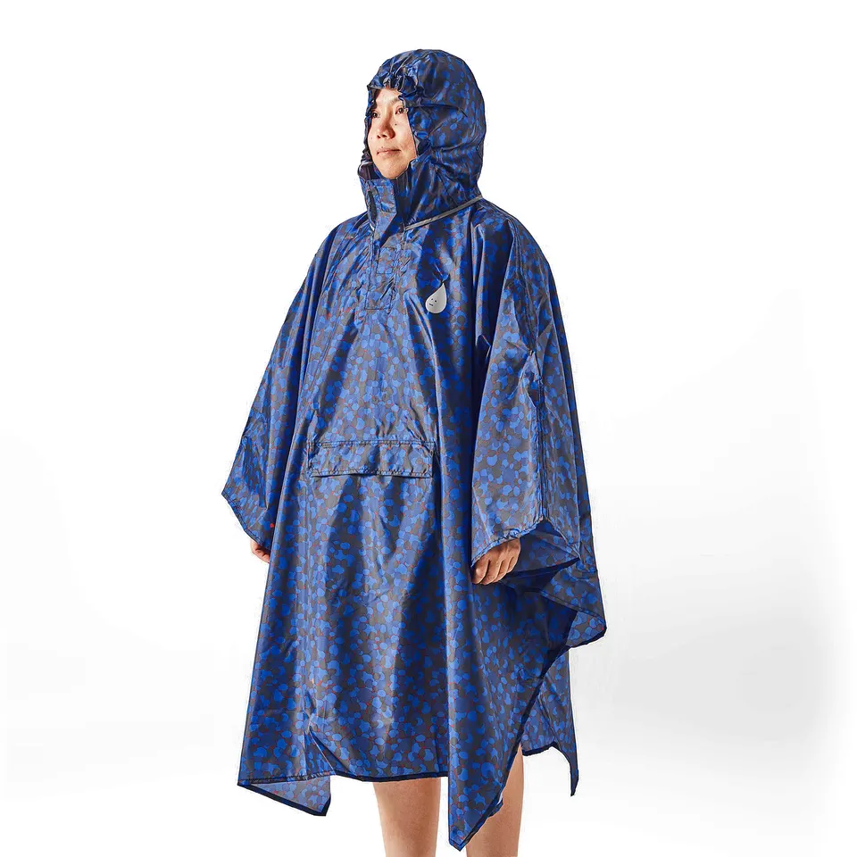 Person wearing a blue patterned rain poncho with a hood.