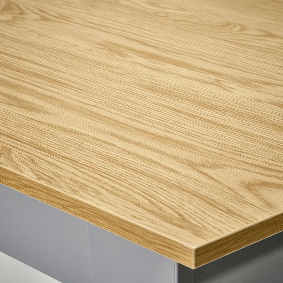 Close-up of a smooth, light wood coffee table top, showcasing its natural grain and fine finish.