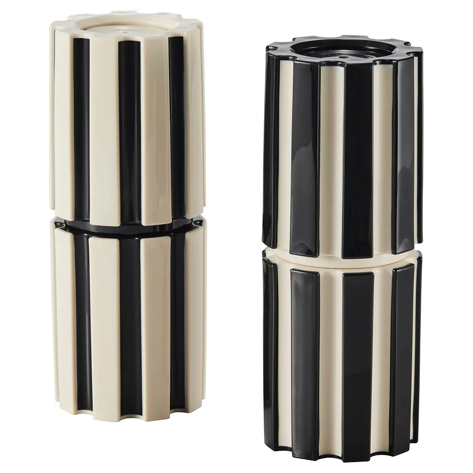 Two black and white striped cylindrical spice mills, stylish, durable with ceramic grinders, stand side by side.