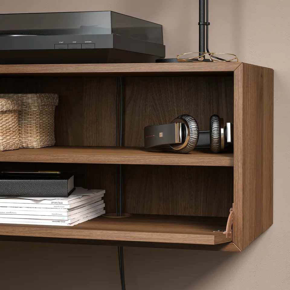 Wooden wall-mounted shelves holding books, records, and headphones.