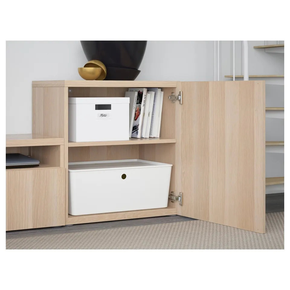 Light wood tv unit with open door revealing storage boxes and shelves.