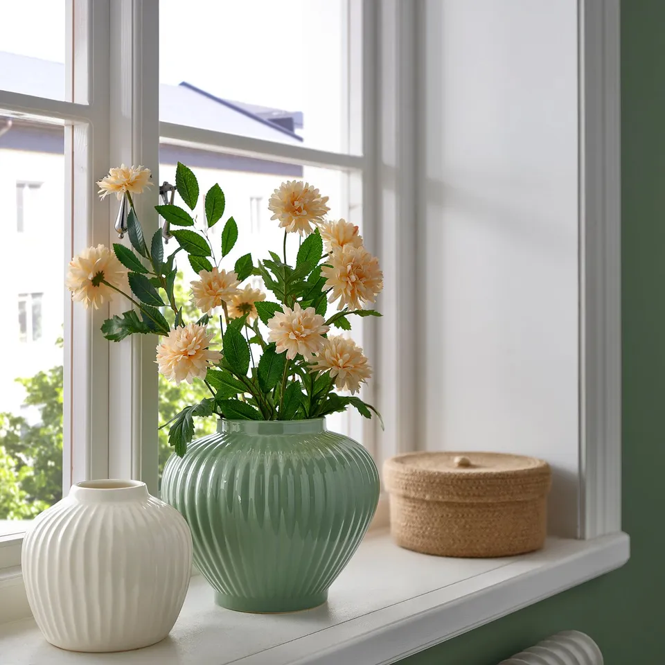 Green PELARBJÖRK vase with flowers on windowsill, glazed stoneware, light-filled room.