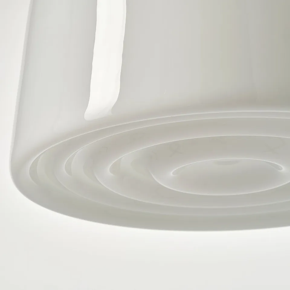 A sleek, modern pendant lamp with intricate circular patterns on its glass shade.