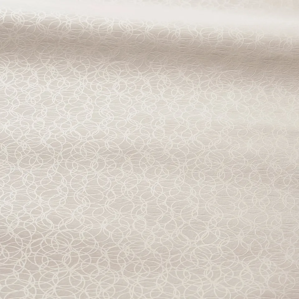 Soft beige roller blind with subtle circular pattern, smooth texture.