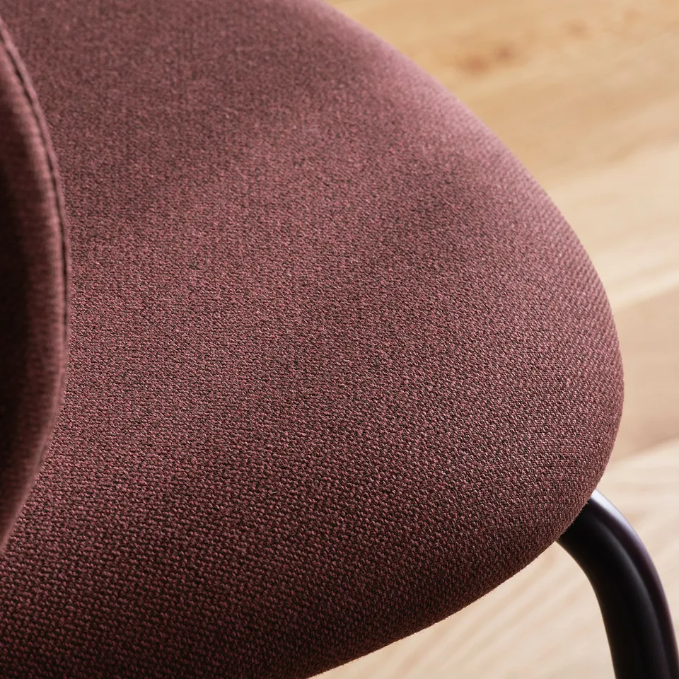 Close-up of an upholstered chair seat in rich brown fabric, showcasing plush texture and quality craftsmanship.