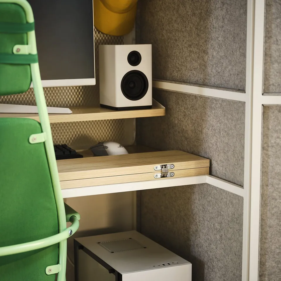 A compact gaming station with shelves holding a speaker, keyboard, and mouse. The desk has a wooden top and felt walls, compatible with a 24 monitor.