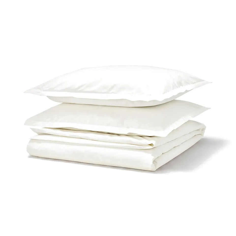 A white HAMPFLOCKEL duvet set with folded sheets and pillows. Cotton material, neatly arranged.