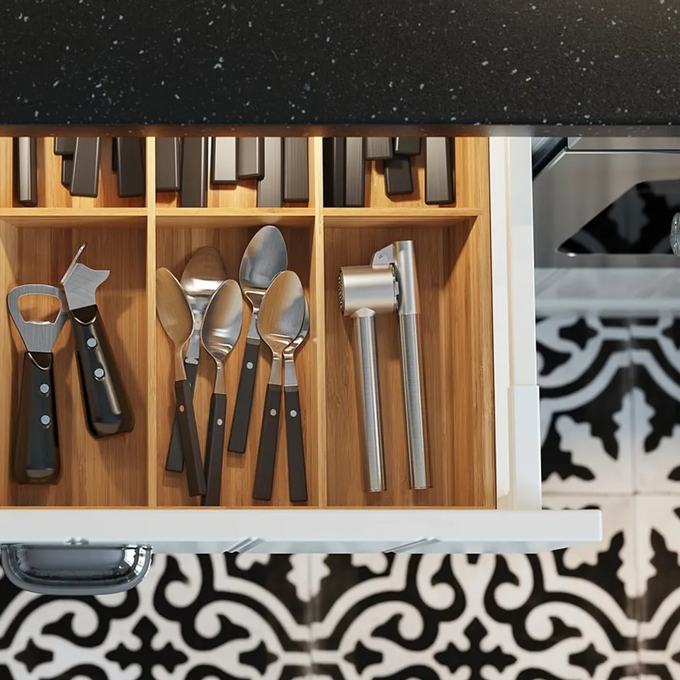 Organised kitchen drawer with modern black and silver utensils. Wooden compartments, led lighting inside.