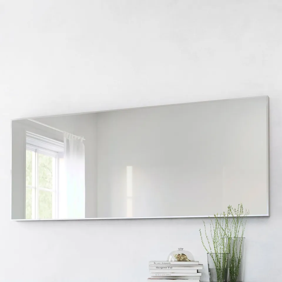 Large rectangular mirror, mounted vertically, reflects window and room. Place near a plant and books for a cosy, organised look. Safety film included.