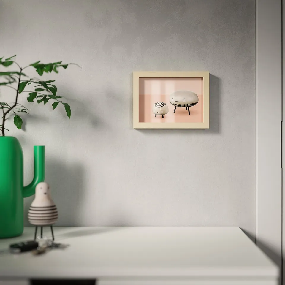 A picture frame with two stools on a grey wall, and a green vase with a plant on a white table below.