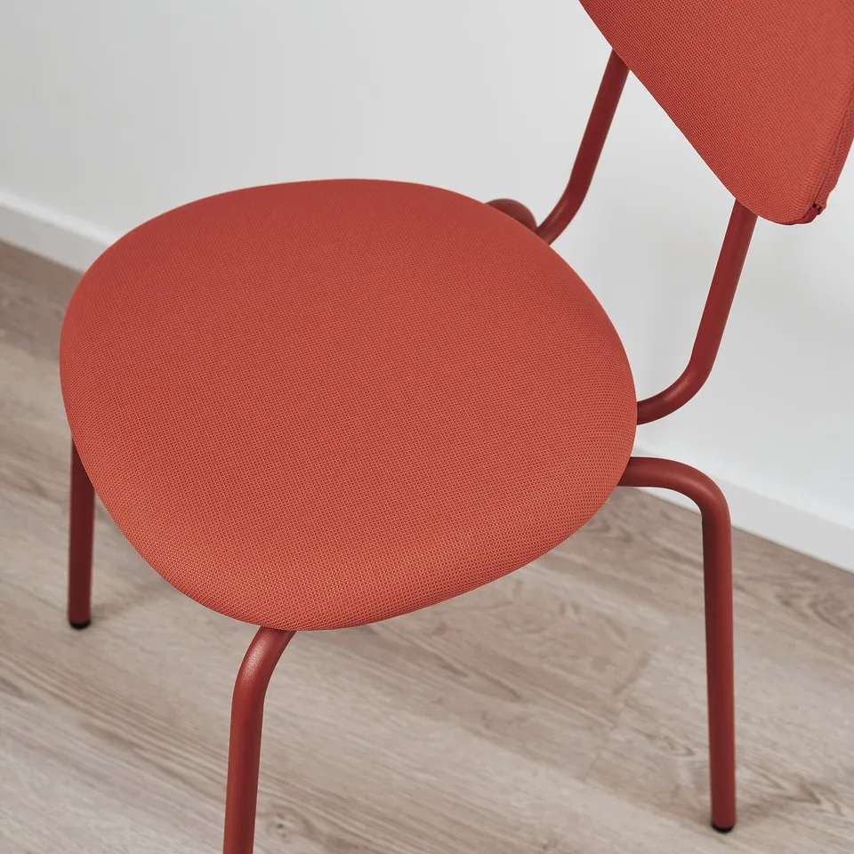 Bright red modern chair with minimalist design, round seat, and metal legs.