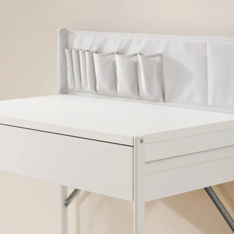 White dressing table with drawer, featuring fabric pockets for organising items. Clean and modern design.
