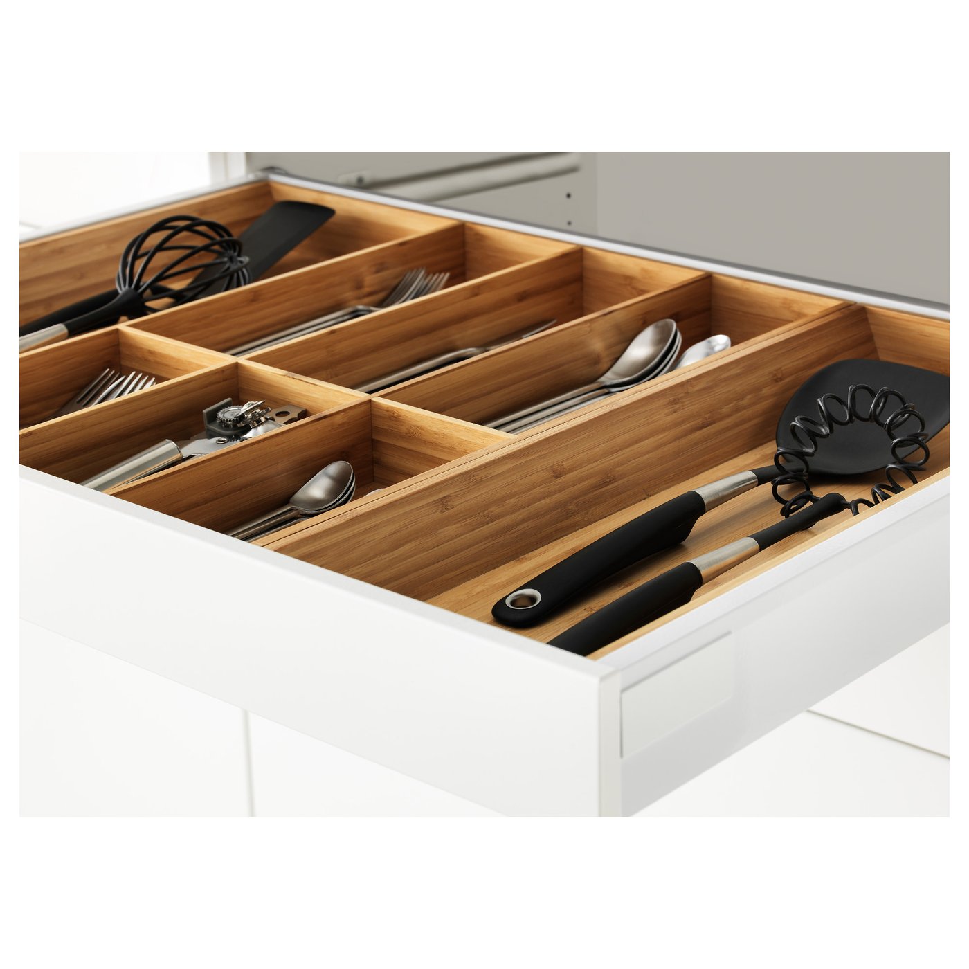 Organised kitchen drawer showing wooden compartments holding various kitchen utensils.