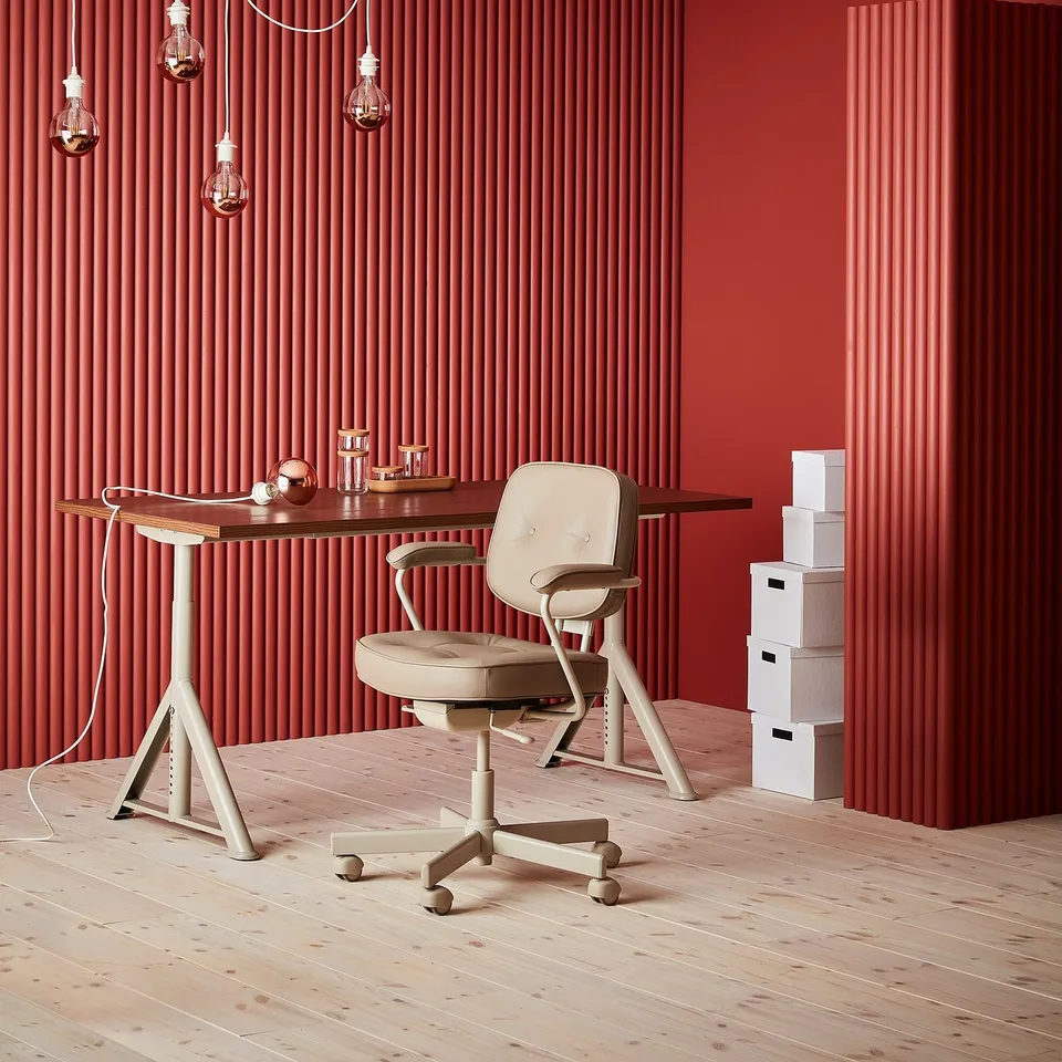 Modern red office with ALEFJÄLL chair, wood desk, hanging lights, white boxes; ergonomic design.