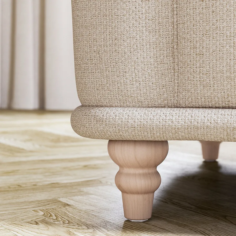 Close-up of beige VISKAFORS sofa leg, rounded design, wooden base.