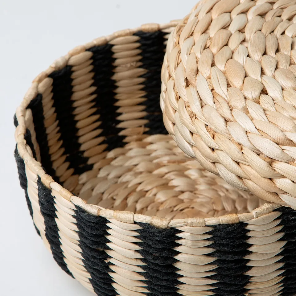 Handwoven round basket with natural and black stripes, showcasing intricate craftsmanship and durable design.
