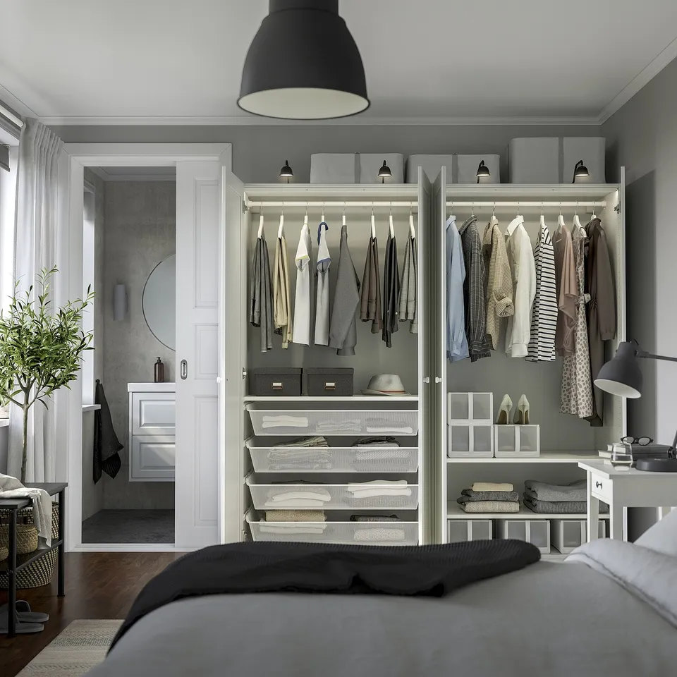 Modern bedroom with built-in wardrobe, pendant light, bed, and bathroom shower.