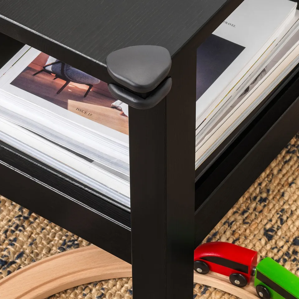 Black corner bumpers protect sharp table edges, ensuring child safety on smooth surfaces.