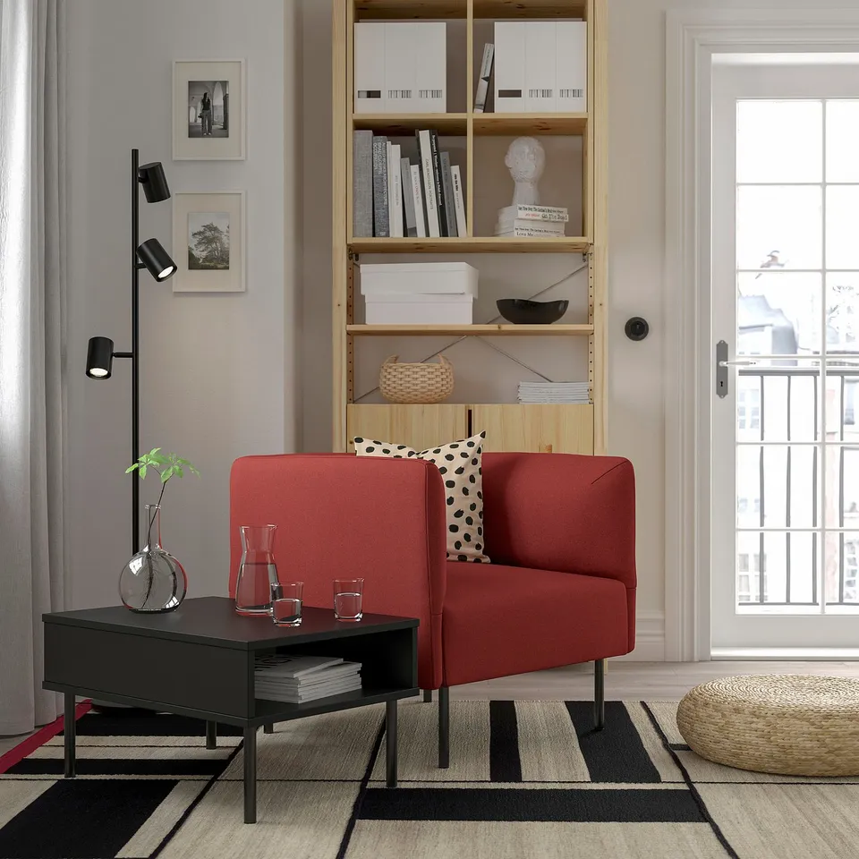 Modern living room with red LILLEHEM sofa, black coffee table, wooden bookshelf, and large window.