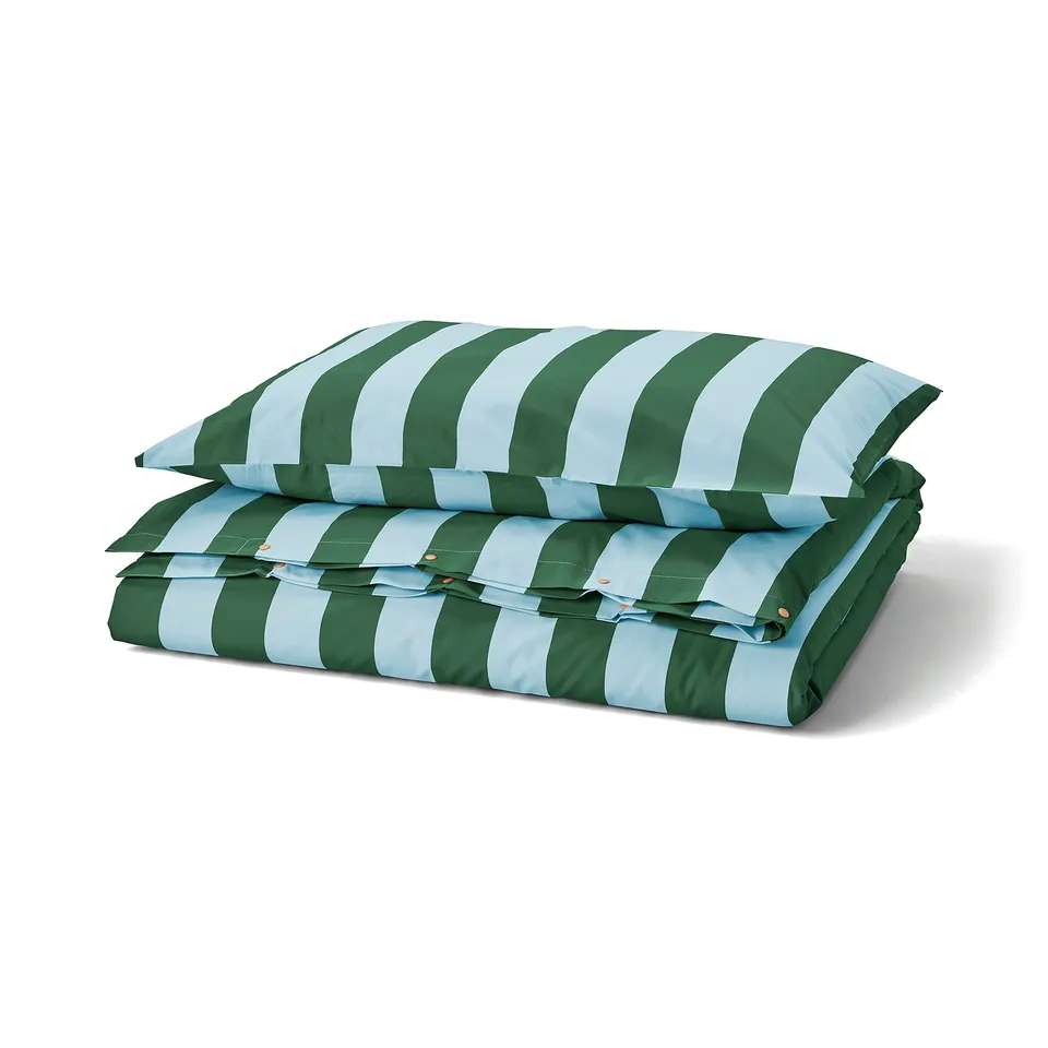 A folded blue-green striped SLÅNHÖSTMAL duvet cover set in cotton and lyocell, neatly stacked with a matching pillowcase.