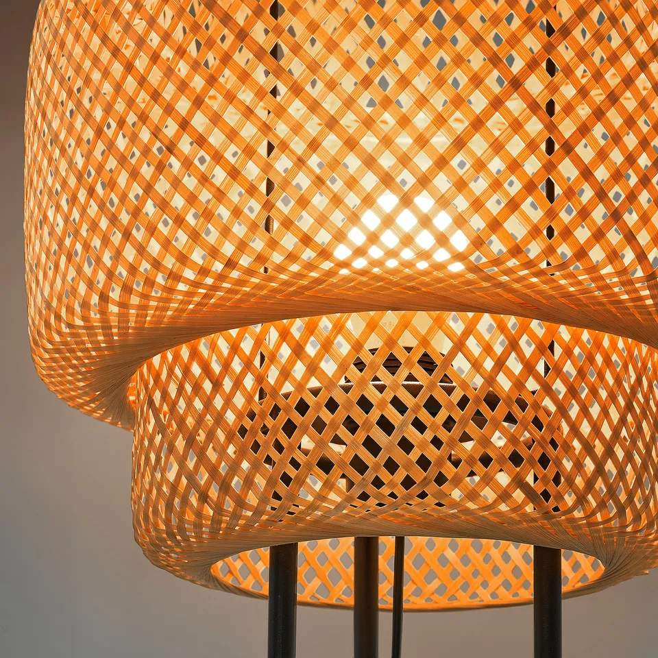 Three intricately woven bamboo lamp shades with warm glowing light. Each shade a diamond pattern, emitting soft, ambient illumination.