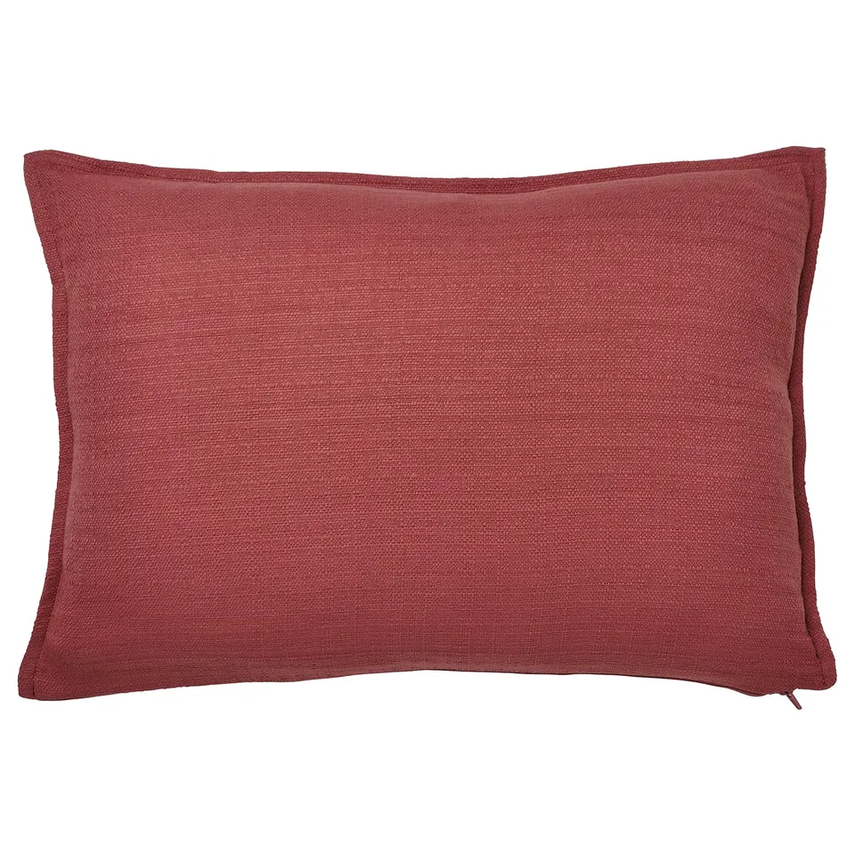 Pink-red cushion, recycled polyester, textured, zip closure.