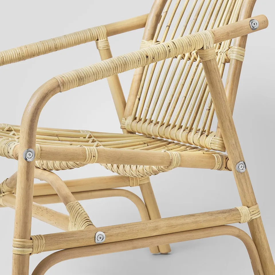 Handwoven rattan armchair with natural finish & curved armrests, sturdy & stylish.