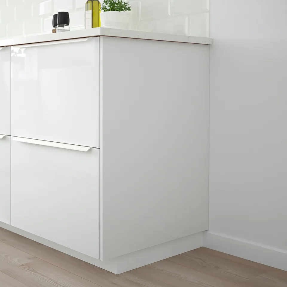 Modern white FÖRBÄTTRA cabinet with glossy finish and minimalist design. Tall unit with small decorative items.