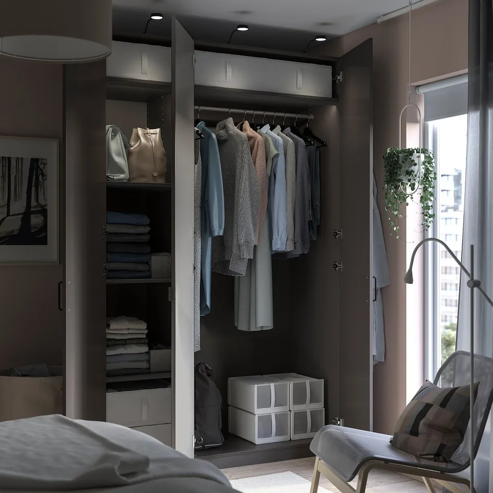 Modern bedroom closet, PAX line, gray-brown, mirror and shelves, neatly organised clothes and folded towels.
