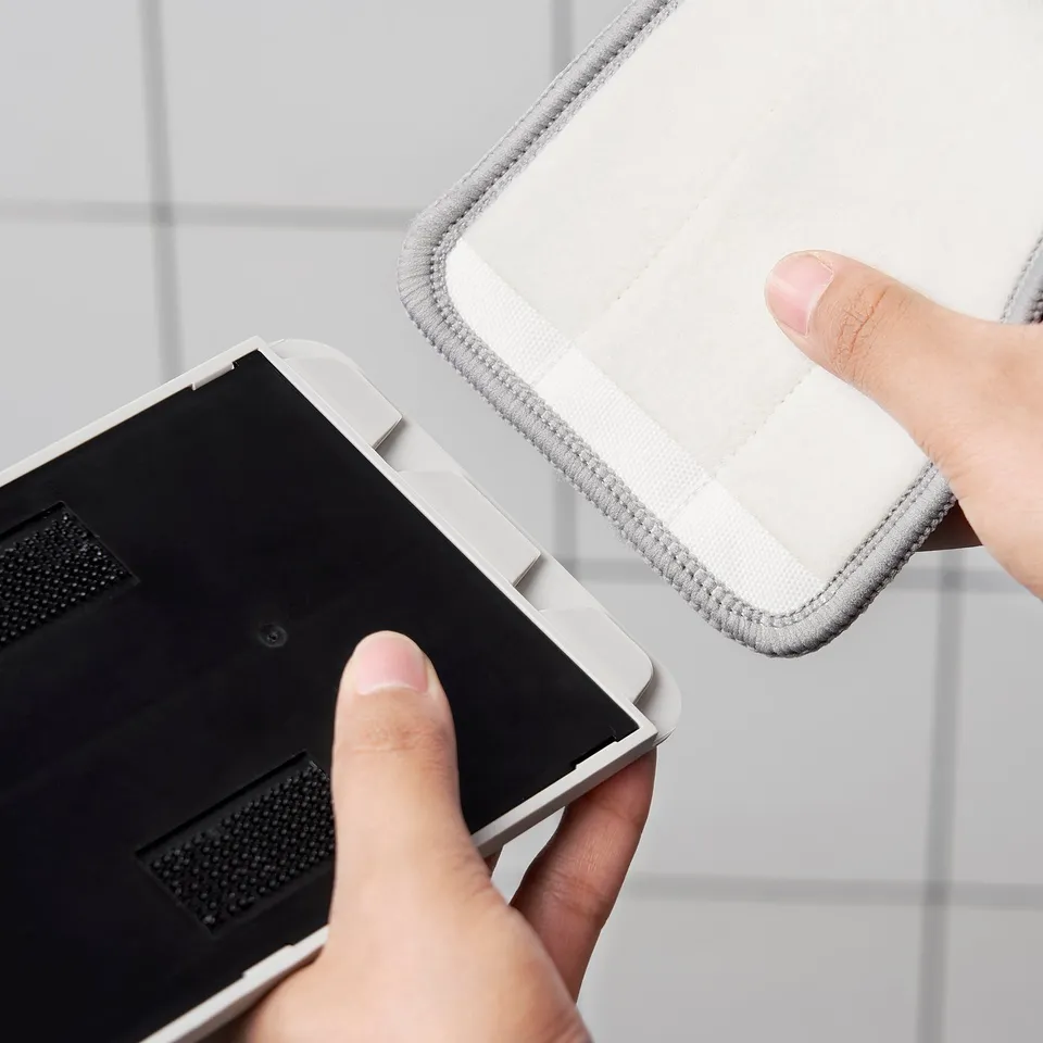Hands holding a microfiber PEPPRIG cloth, designed for a squeeze-clean mop, showcasing its quick-drying and absorbent.