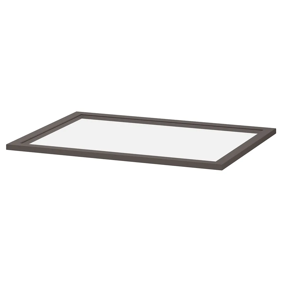 A dark-colored rectangular glass shelf by IKEA. The frame is made of fibreboard with a sleek design, suitable for modern storage solutions.