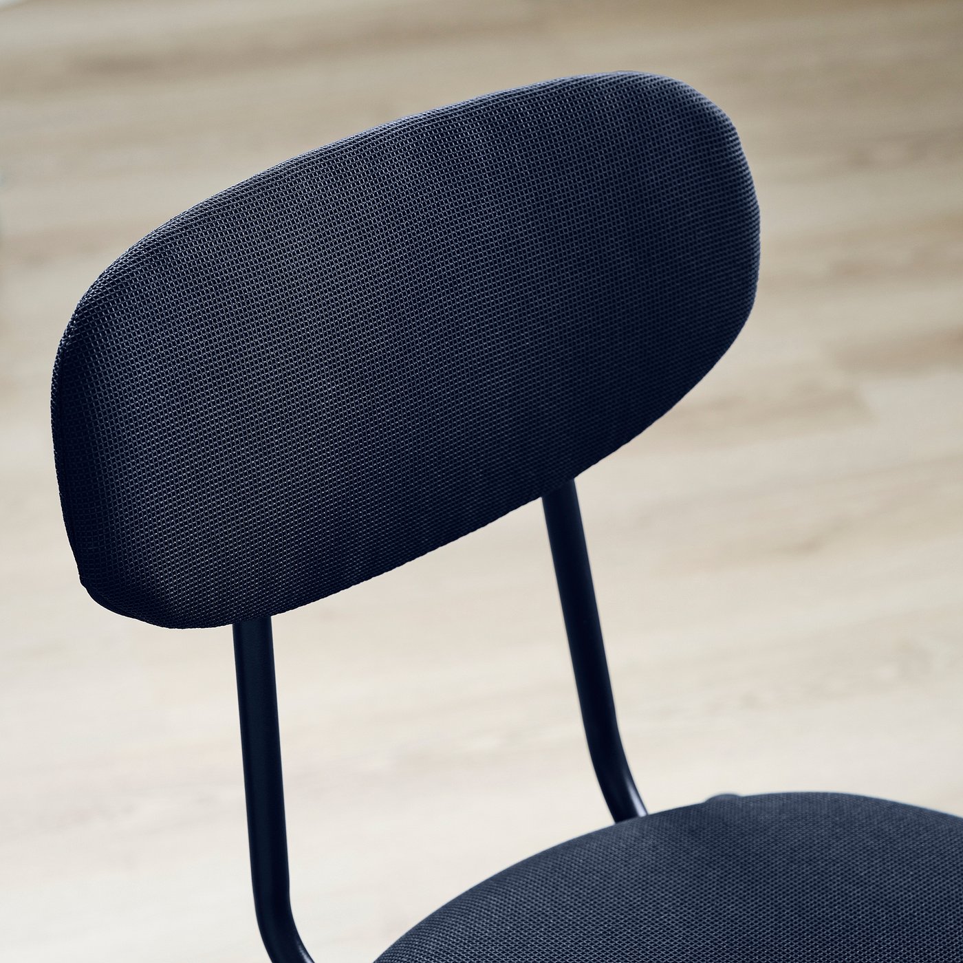 Modern chair with sleek black upholstery and curved backrest, showcasing excellent craftsmanship and ergonomic design.