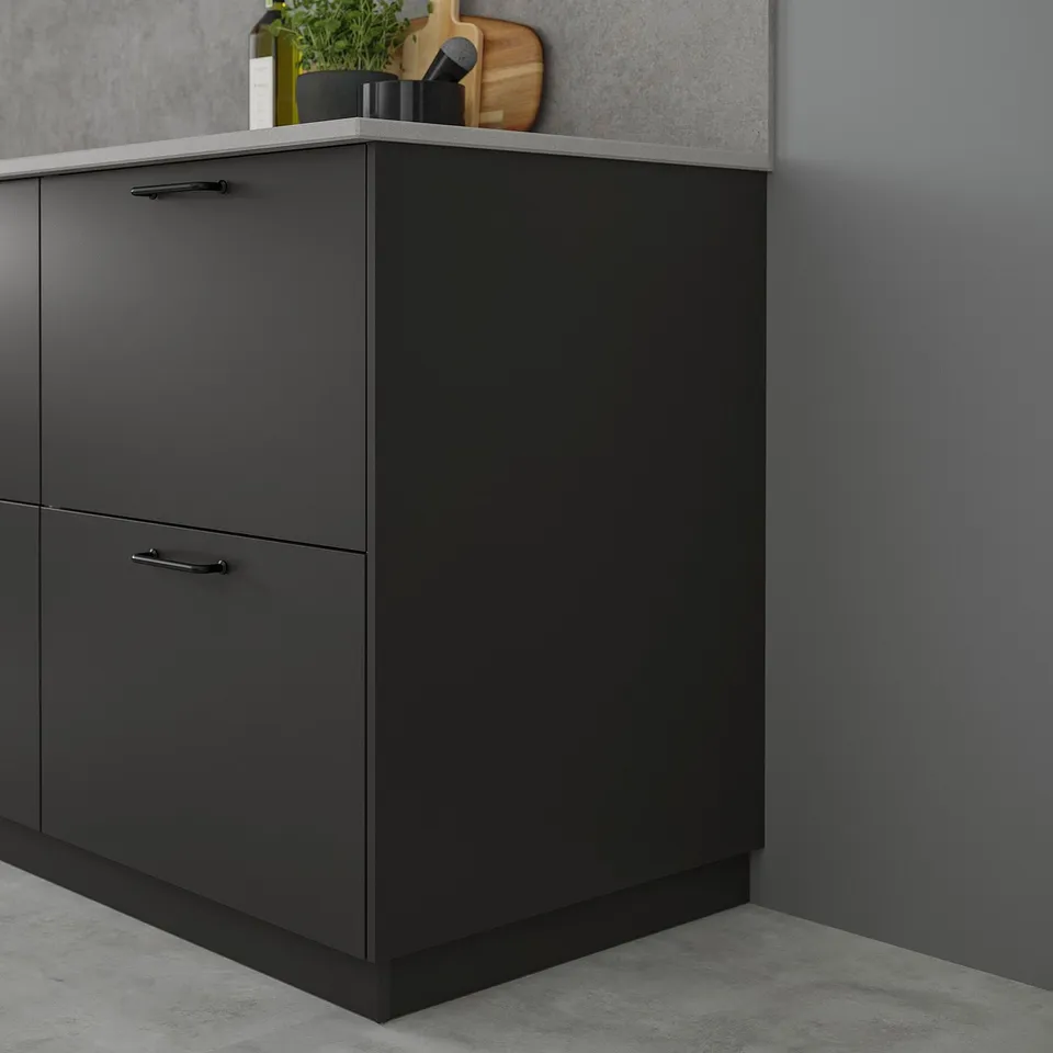 Black kitchen cabinet with sleek, minimalist design. Its a tall unit, narrower than nearby wall, featuring smooth surfaces and subtle handles.