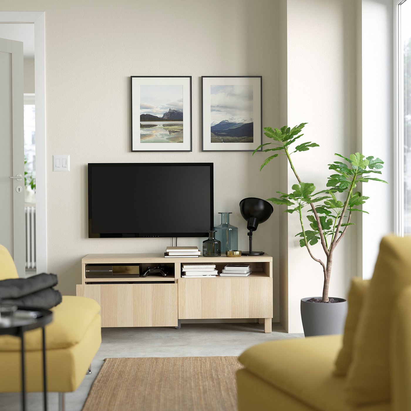 Modern living room with tv and decor on shelves between yellow armchairs.