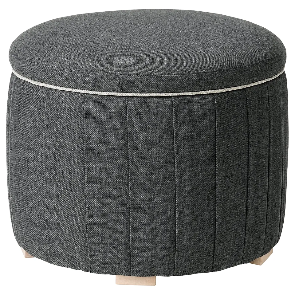 Round grey fabric stool with wooden legs, pleated sides, and thin piping around the top.