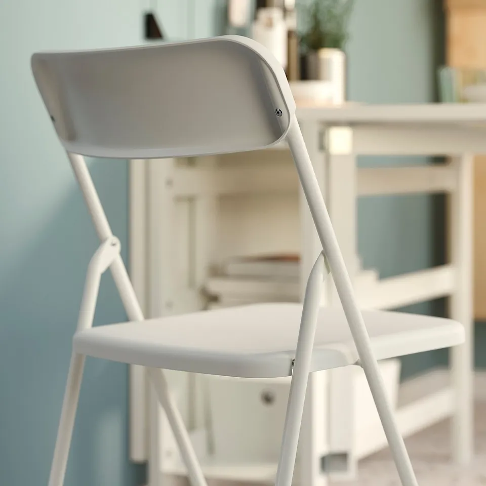 A white GUNDE folding chair, shown in its open position, ideal for space-saving.