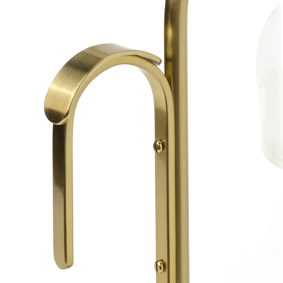Gold-colored metal hook on a lamp, securely fastened with screws.