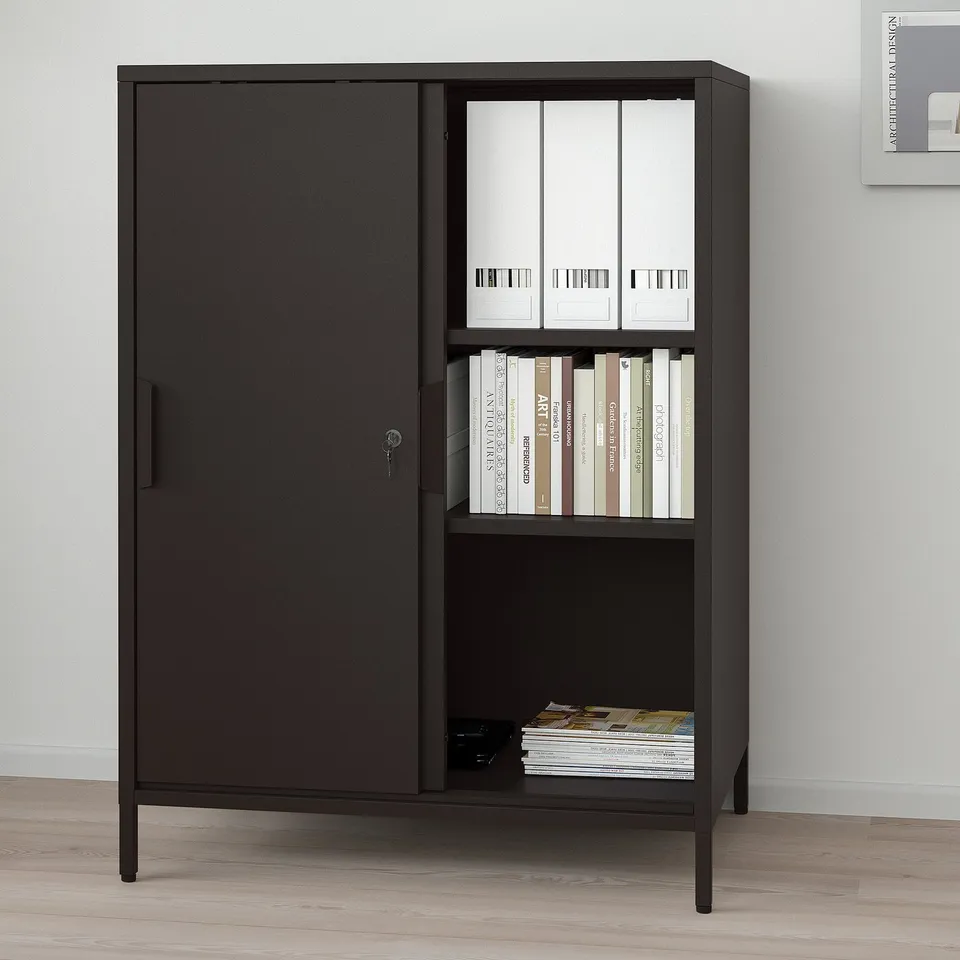 Black cabinet with sliding doors and open shelves, holding books and binders, for locked and open storage.