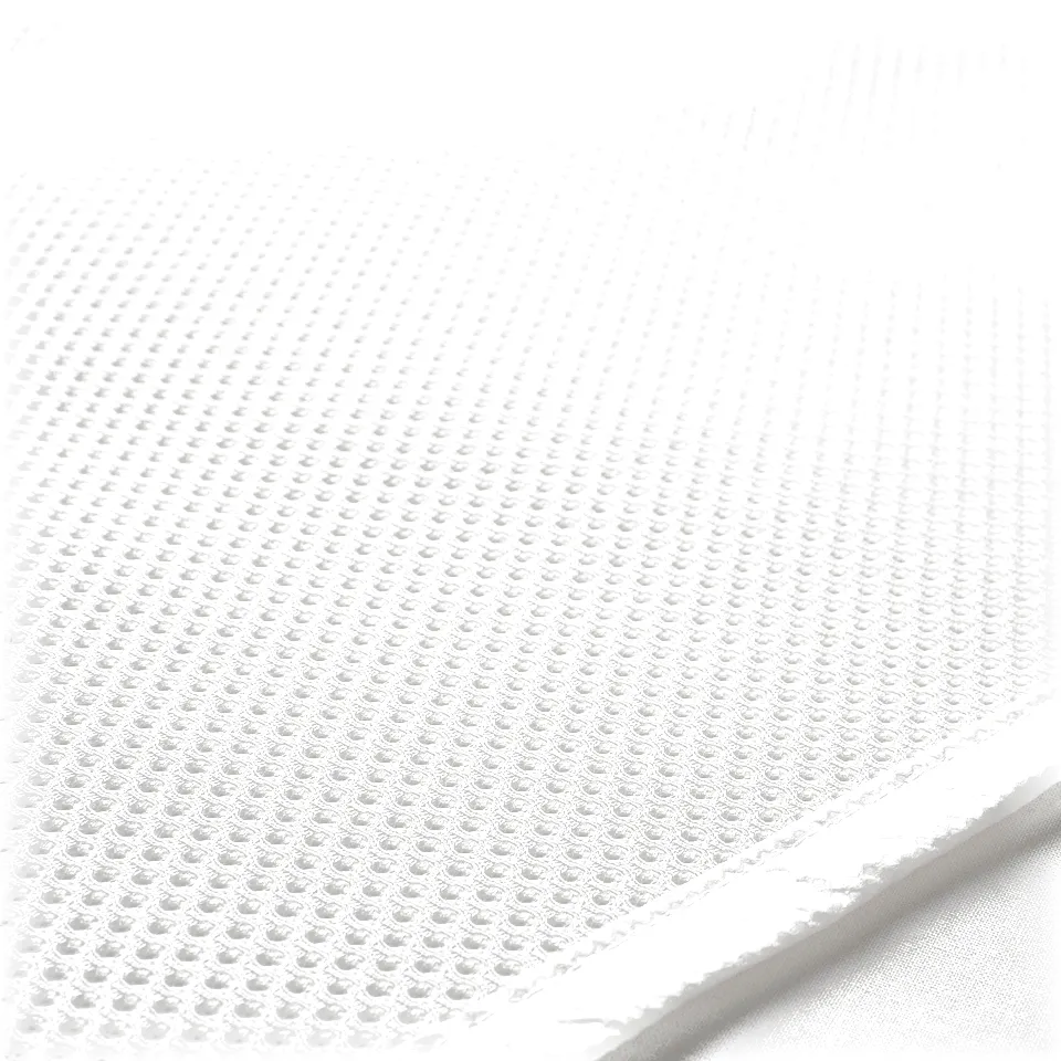 Close-up of a white mattress protector showing its textured, breathable mesh material and sealed edge.