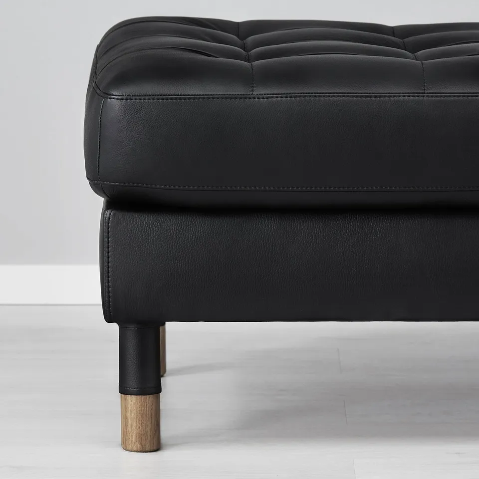 Slick black leather sofa with angled legs. High end, modern furniture.