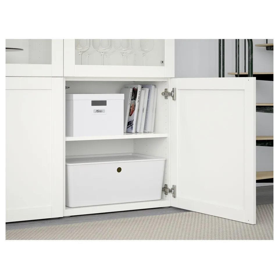 White BESTÅ cabinet with adjustable shelves, soft-close doors, and both open and closed storage compartments.