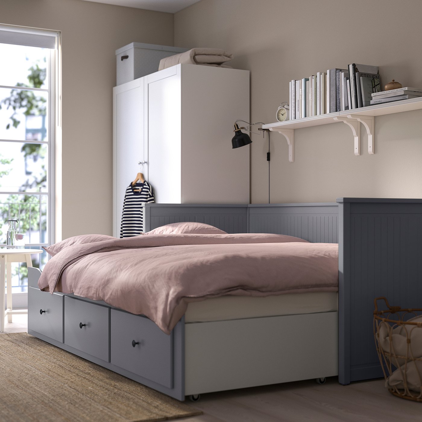 Bedroom a HEMNES day-bed with storage drawers, transforming into a double bed, and paired with a tall storage unit and wall-mounted bookshelf.