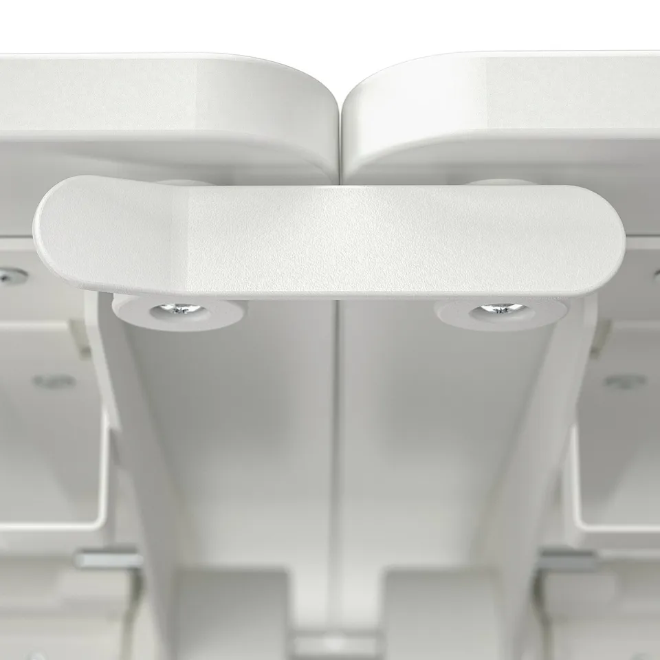Close-up of modern, white conference table with adjustable footrest and sturdy metal legs.