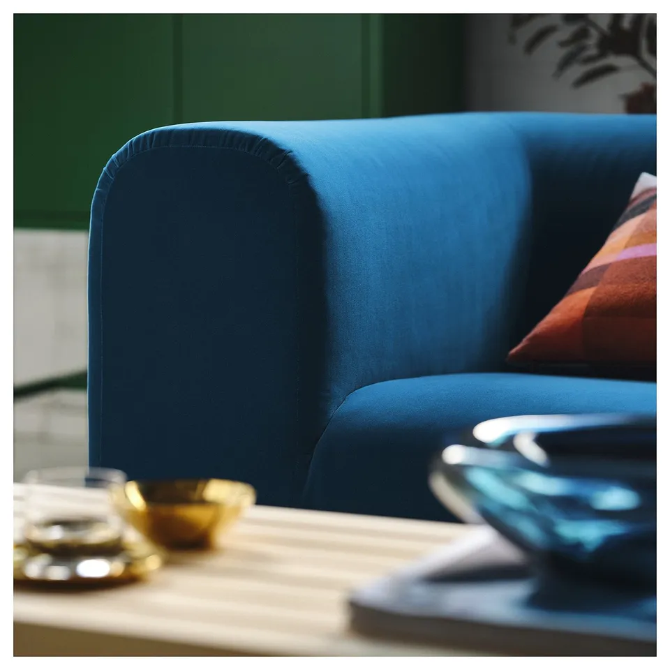 A close-up of a blue sofas armrest, showcasing its sturdy, high-quality upholstery.