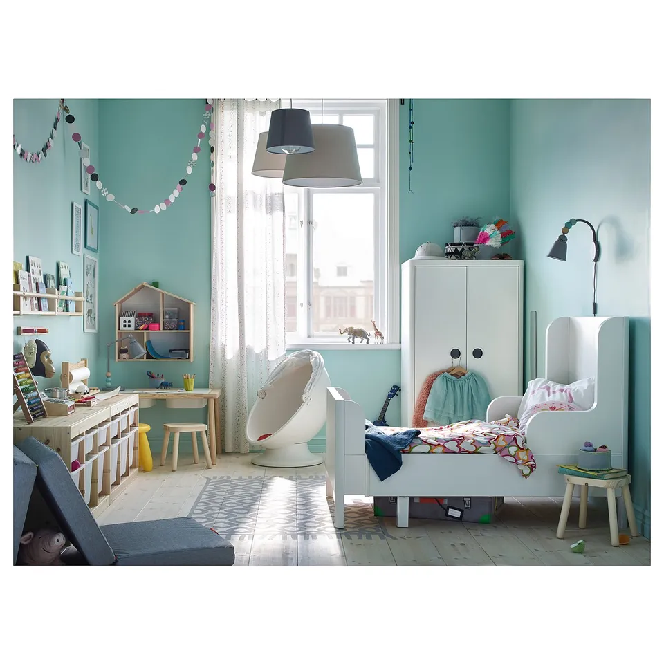 Childs room: BUSUNGE bed, blue linens, desk, chair, shelves, lamps, window.